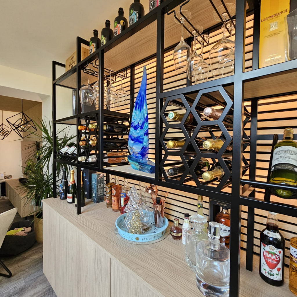 Bespoke oak wine storage and home bar unit featuring custom shelving, bottle racks, display storage and black metal detailing.