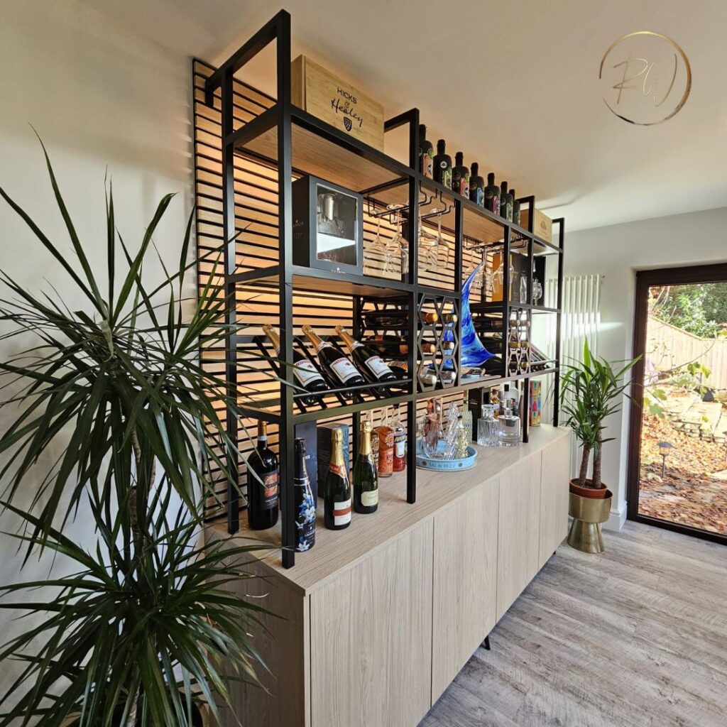 Bespoke drinks display cabinet with open shelving, metal framework, integrated cabinetry and decorative bottle storage.