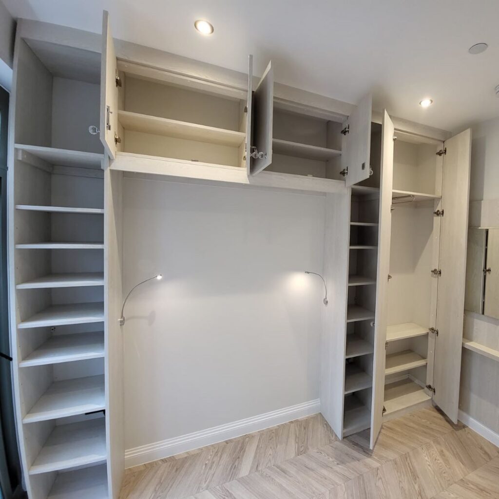 Bespoke fitted wardrobe with integrated shelving, hanging rails, overhead storage and custom bedroom cabinetry.